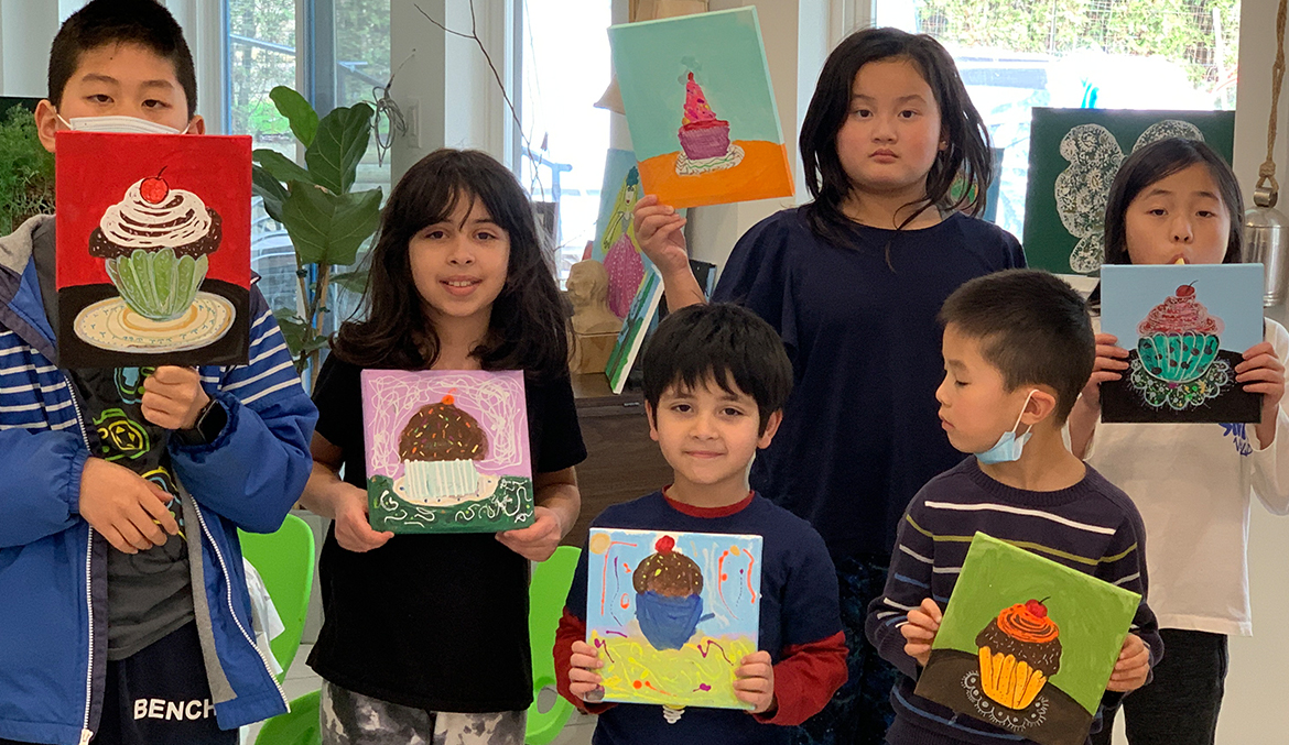 Children holding art that they've made during Annar Childcare Afterschool Program